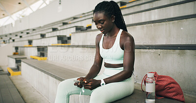 Buy stock photo Stadium, black woman and typing with smartphone for fitness, online communication and scroll on app. Outdoor, female person and relax with mobile for chat message, social media and break for exercise