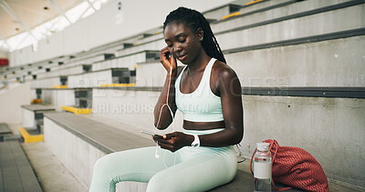 Buy stock photo Earphones, fitness and black woman with phone on break with music, playlist or radio for workout rest. Audio tech, sports and African athlete listening to album on stairs for exercise or training.