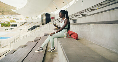 Buy stock photo Athlete, black woman and relax with phone at stadium for social media, fitness app and event agenda. Female person, rest and mobile for texting, sports progress results and information for tournament