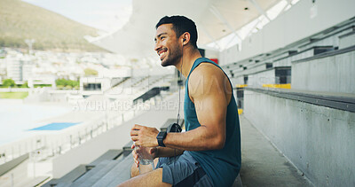 Buy stock photo Stadium, man and earphones with water bottle for fitness, hydration and running break. Outdoor, athlete person and thinking with smile for training podcast, exercise and music for workout rest