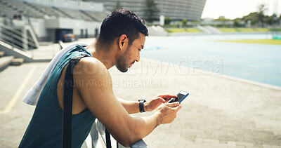 Buy stock photo Athlete, man and browsing with phone at stadium for social media, fitness app and event agenda. Male person, rest and mobile for texting contact, sports progress results and information on tournament