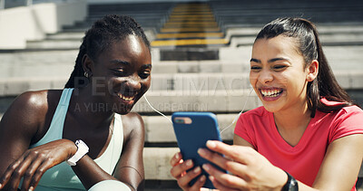Buy stock photo Phone, fitness and girl friends with earphones outdoor for listening to music, networking or social media. Laughing, sports and female athletes on break streaming playlist on mobile app on stairs.