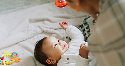 Buy stock photo Mother, baby and playing with toy at house for sensory fun, motor growth and coordination. Woman, curious infant and sound rattle for entertainment, stimulation games and bonding of child development