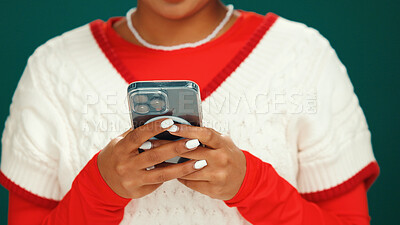 Buy stock photo Christmas, phone and hands of woman in studio with networking, communication or social media. Technology, xmas contact and person with cellphone for online, mobile app or texting by green background.