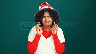Buy stock photo Christmas, fingers crossed and woman in studio, wish and winning with faith on green background. Xmas, space and person with hand gesture, excited and miracle with hope, holiday season or eyes closed