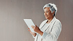 Mature businesswoman, tablet and wall at office, smile and scroll with mockup space for contact on web. Person, happy and tech with application, typing and review for revenue report at finance agency