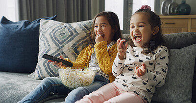 Buy stock photo Happy girl, sisters and watching TV with popcorn on sofa for funny cartoon or movie in home. Child, siblings or kids laughing with snack or remote for online entertainment or subscription in house