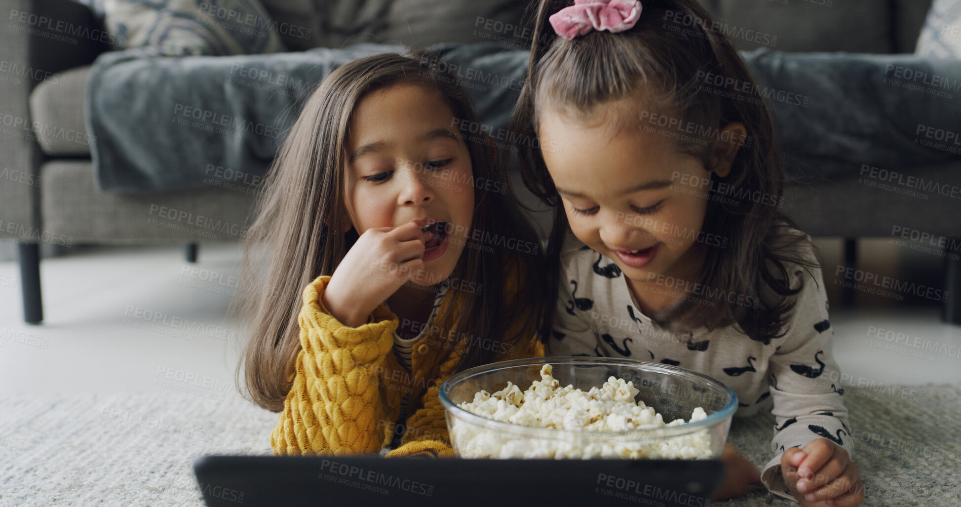 Buy stock photo Popcorn, streaming and tablet with girls on floor in living room of home for subscription service. App, eating and smile with sister children in apartment together for bonding or video entertainment