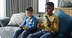 Video games, friends and boys on sofa celebrate for playing, fun and online entertainment together. Loser, living room and children with controller for gaming, competition and winning on weekend
