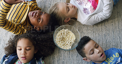 Buy stock photo Popcorn, media and group of children on floor in home for playing online games on app together. Friends, technology and top view of kids with snack and cellphone for watching movie or show in house.