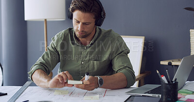 Buy stock photo Architect, headphones or man with planning on blueprint for building layout, design ideas or strategy. Architecture, person or sticky notes with music at desk for construction guide or project review