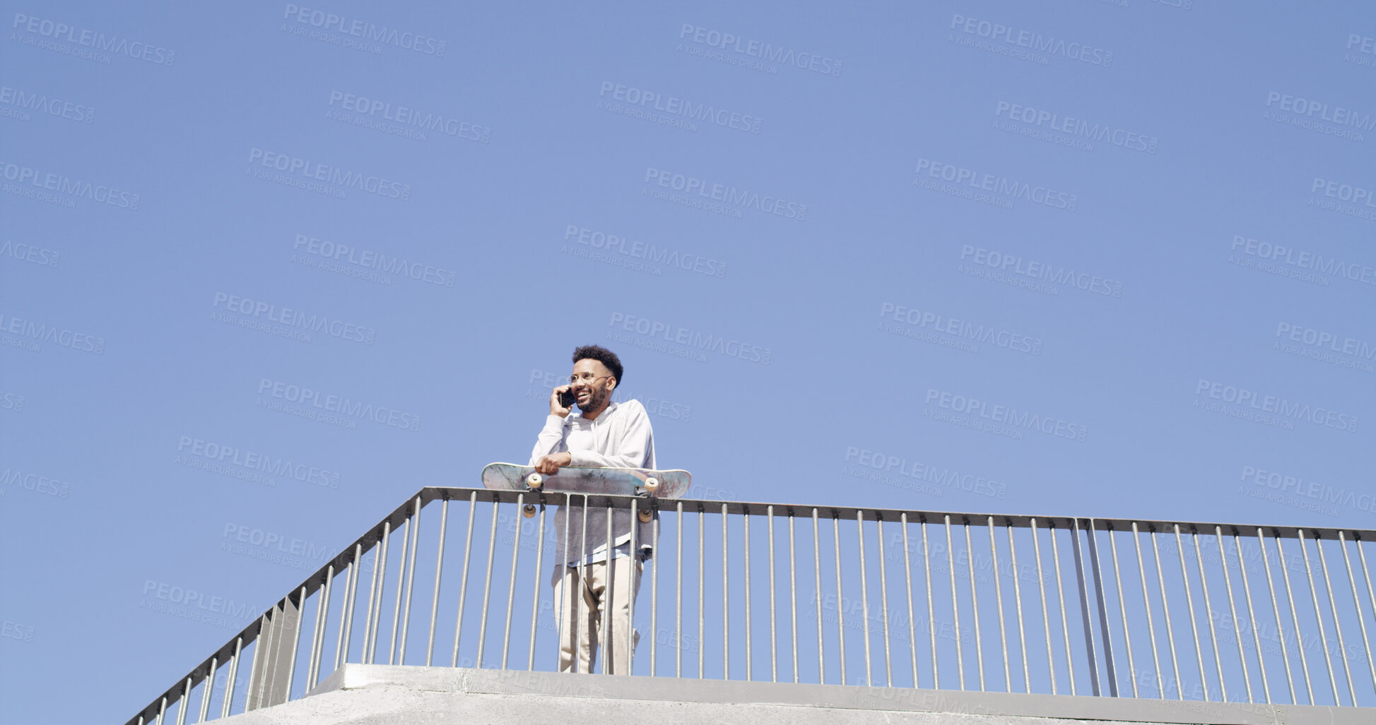 Buy stock photo Man, skateboard and talking with phone call at park for lesson schedule, training plan or feedback. Mockup space, blue sky and happy skater at skatepark for conversation, practice update or low angle