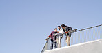 Below, people and laughing with skateboard, phone and meme together on blue sky space. Bonding, friends and gen z skater group with tech, smile and social media for fitness hobby and break for sport