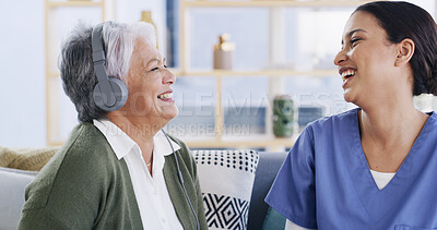 Buy stock photo Headphones, healthcare and nurse with funny old woman in assisted living apartment for bonding. Laughing, medical or music with caregiver and senior patient on sofa in home for audio streaming