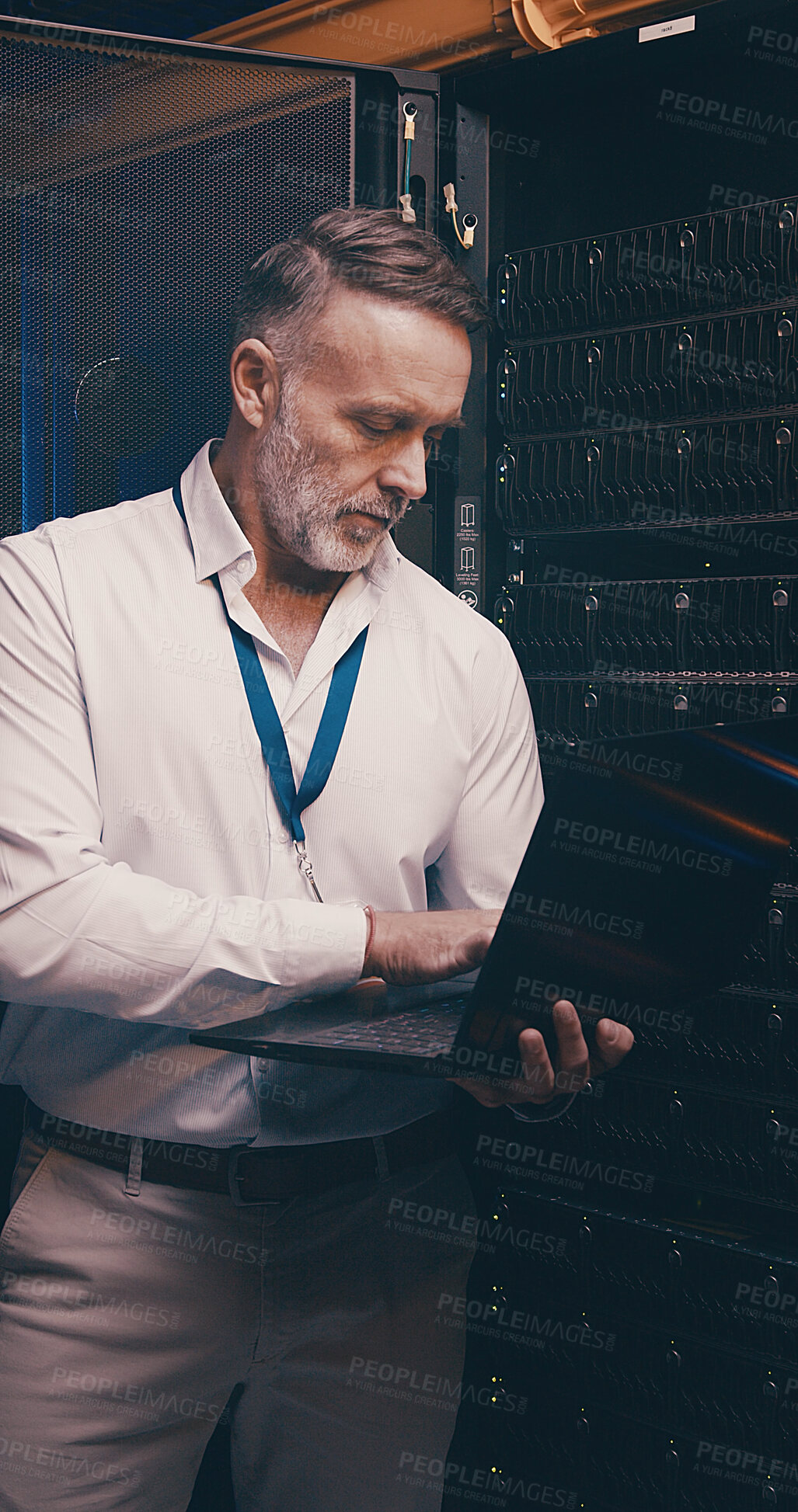 Buy stock photo Server room, programmer and man with laptop, cyber security and hardware problem solving. IT specialist, mature person or employee with pc, engineering and tech upgrade with inspection or maintenance
