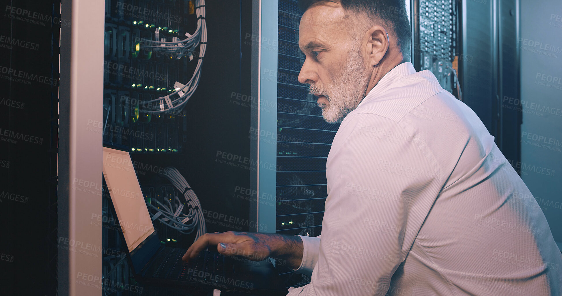 Buy stock photo Engineer, man or typing on laptop in server room for diagnostics, system test or maintenance. Technician, mature person or technology in data center for network configuration, software update or GDPR