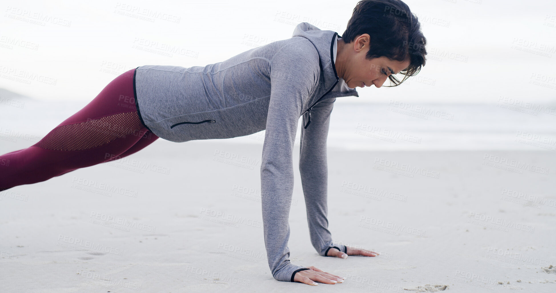 Buy stock photo Athlete, woman and pushup for exercise by ocean for fitness, strength training and strong muscles. Female person, weight and workout routine, body balance and sports performance for wellness at beach