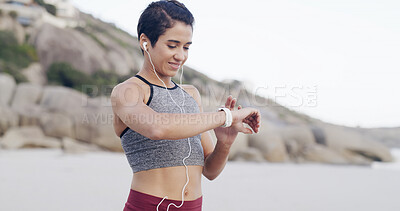 Buy stock photo Fitness, music and woman with smart watch at beach for heart rate, exercise progress or results. Earphones, happy runner and check wristwatch for wellness stats, timer and pace tracking for cardio