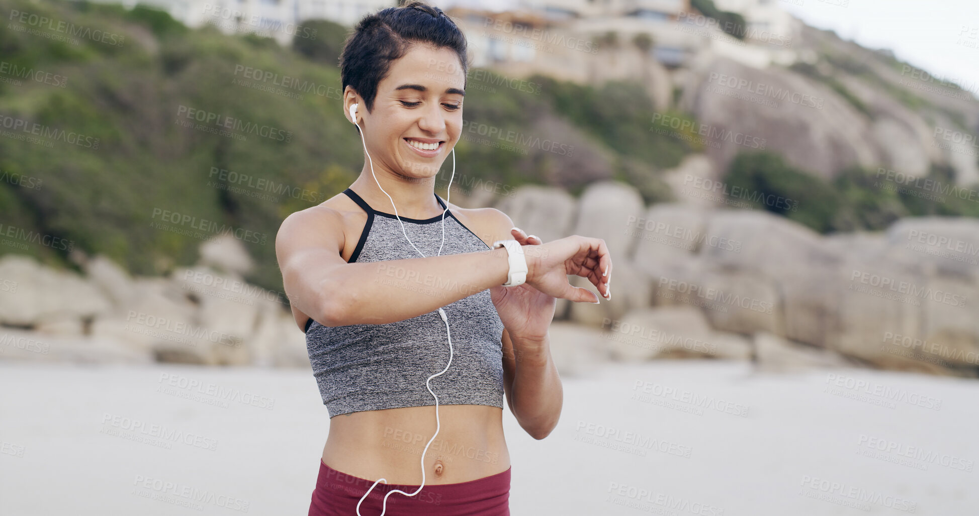 Buy stock photo Fitness, earphones and woman with smart watch at beach for heart rate, exercise information or pulse. Music, happy runner and check wristwatch for wellness stats, timer and tracking pace outdoor