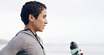 Fitness, water bottle and woman by ocean for exercise, training and workout in nature. Sports, thinking and person with liquid, minerals and nutrition for wellness, health and hydration outdoor