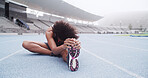 Stretching, fitness and woman on track in stadium to start running, exercise and marathon training. Athlete, sports and person with leg warm up for workout, race competition and challenge outdoor