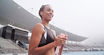 Happy, sports and woman with water in stadium for exercise, training and workout on running track. Fitness, athlete and person with drink, bottle and thirsty for wellness, health or hydration outdoor