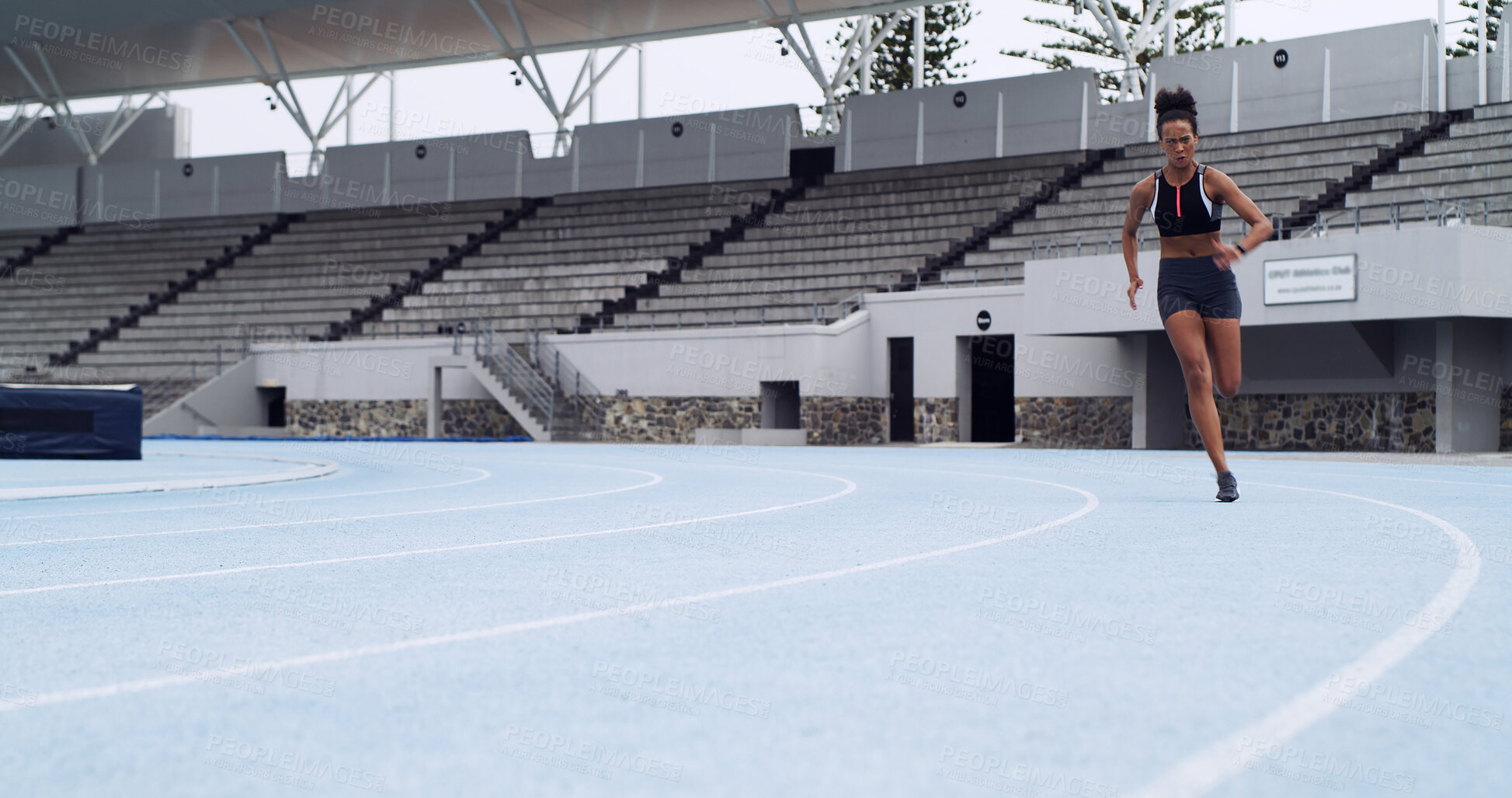 Buy stock photo Athlete, fast runner and woman on race track with fitness, training and cardio performance. Sprinter, speed or female person with running at stadium space for sports, practice and exercise challenge