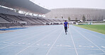 Runner, athlete and back at stadium for sports competition, sprint or fitness practice. Training, speed and person outdoor as track running, marathon and space for workout and wellness in lane