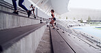 Woman, running and stairs at stadium for fitness, cardio exercise and marathon practice. Athlete, people and training on steps for endurance routine, sports workout and race preparation for challenge