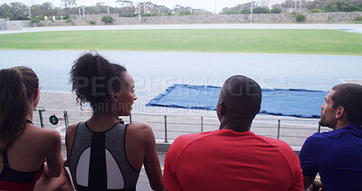 Buy stock photo Talking, team and athlete on break, stadium or people on bleachers for competition or communication. Back, fitness and view of sports field, rest and runner with sportswear, wellness and outdoor