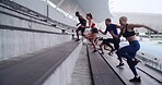 Athlete, group and running on stairs with exercise for competition training, endurance or energy. Teamwork, people and workout on steps at stadium for sports performance, health routine and stamina