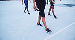 Runner, walking and fitness with legs on race track for marathon practice, workout and cardio challenge. Sports athlete, exercise and competition with people in stadium for health, training or sprint