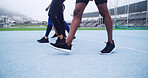 Runner, walking and sports with legs on race track for marathon practice, workout and cardio challenge. Fitness athlete, exercise and competition with people in stadium for health, training or event