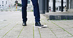 Legs, business and person with shoes in city for travel, pickup documents and litter accident. Man, feet and standing on paper to reduce waste, clumsy employee and trash flyer for career opportunity
