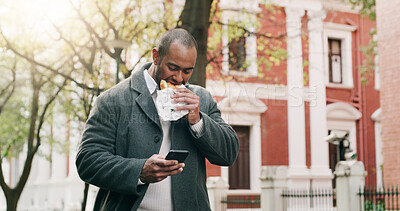Buy stock photo Man, phone and eating food for travel in city, browsing social media and lunch break. Male person, walking and mobile app with healthy meal, direction search and notification update for urban trip