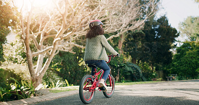 Buy stock photo Girl, back and bicycle in neighborhood, street and ride on adventure, learning and helmet for safety. Child, bike and outdoor with cycling gear, fun and summer at park on road by trees in nature