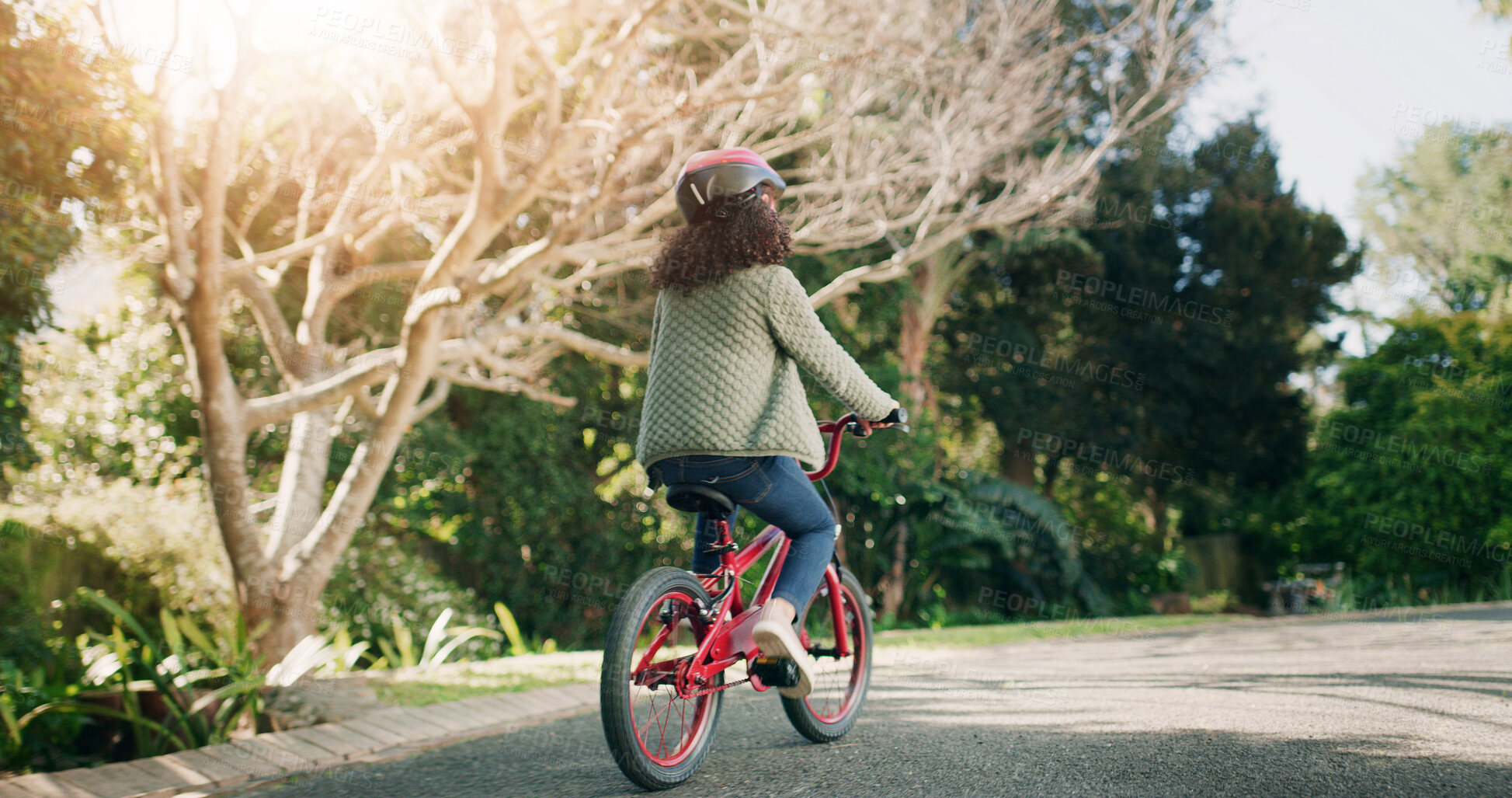 Buy stock photo Girl, back and bicycle in neighborhood, street and ride on adventure, learning and helmet for safety. Child, bike and outdoor with cycling gear, fun and summer at park on road by trees in nature