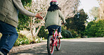 Father, hands and teaching child on bicycle with support, learning skills and development in road. Back, safety and parent with girl on bike for cycling, trust and childhood memory in neighborhood