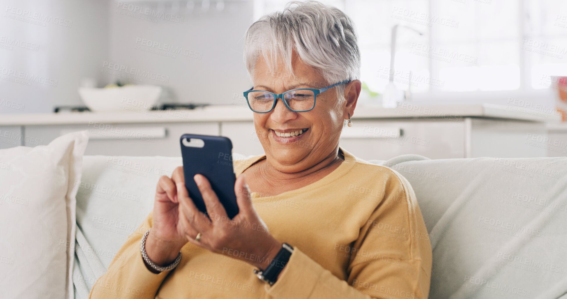 Buy stock photo Senior woman, phone and smile on sofa for typing message, reading ebook or search online news. Retirement, old person and relax with smartphone in home for social media update or playing puzzle game