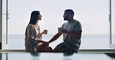 Buy stock photo Ocean, window and couple with coffee, home and bonding together with romance, relax or discussion. Apartment, talking or man with woman, relationship or cappuccino with break, seaside or conversation