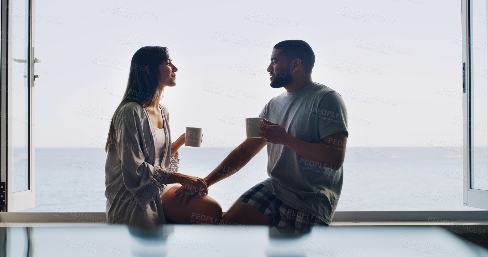 Buy stock photo Ocean, window and couple with coffee, home and bonding together with romance, relax or discussion. Apartment, talking or man with woman, relationship or cappuccino with break, seaside or conversation