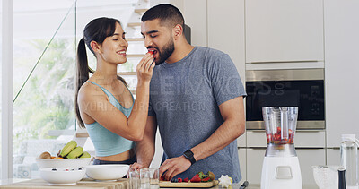 Buy stock photo Feeding, home and couple in kitchen, strawberry and hungry with support, fruits and weight loss. Gut health, blender or man with woman, smoothie or nutrition with vitamins, relationship or eating