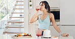 Headphones, drinking smoothie and woman with healthy diet, nutrition and fruit in kitchen. Taste, blender and female person with vegan ingredients for drink, shake or streaming music in home