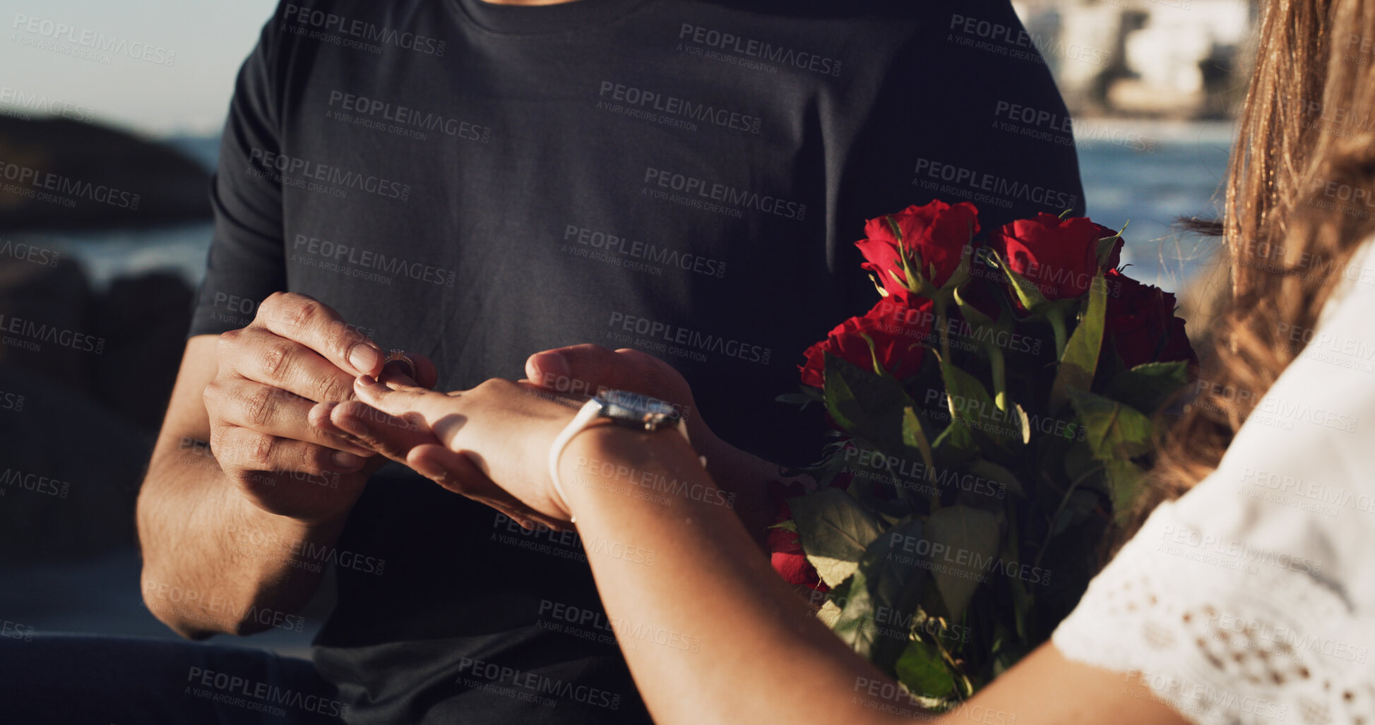 Buy stock photo Engagement, love and hands of couple at beach for marriage proposal, romance and support. Wedding ring, roses and vow renewal on anniversary with man and woman for commitment and save the date