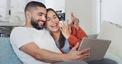 Buy stock photo Tablet, smile and happy couple in living room for video call, announcement and engagement on home sofa. Hug, technology and excited man with woman, website and social media or internet communication