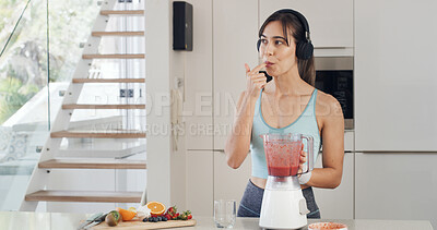 Buy stock photo Headphones, smoothie and thinking with a woman for healthy diet, nutrition and fruit in kitchen. Taste, blender and female person with vegan ingredients for drink, shake or streaming music in home