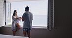 Smile, couple and relax by window at house with love, start day and calm morning on honeymoon. Happy, people and hotel at sea for romance, partner loyalty and bonding together for marriage commitment