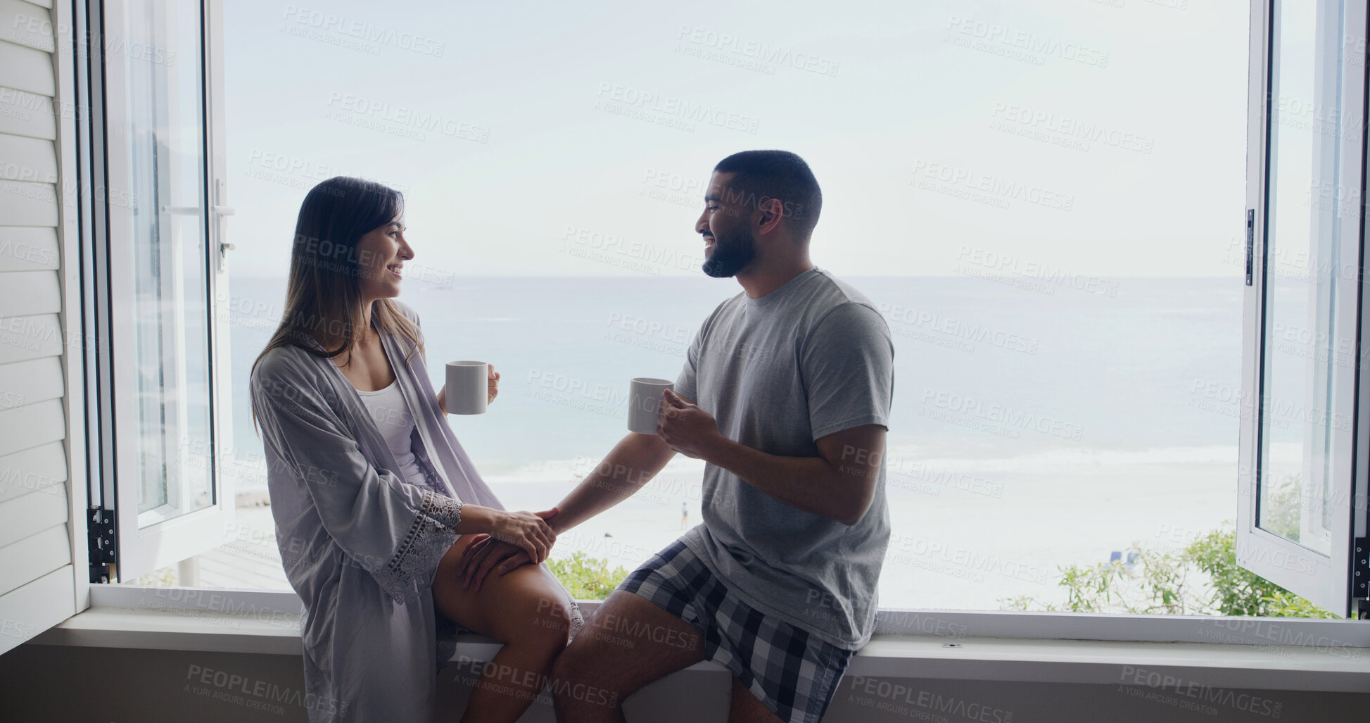 Buy stock photo Ocean, window and couple with coffee, home and holding hands with relationship, relax and discussion. Apartment, seaside and happy man with woman, talk or cappuccino with break, conversation and love