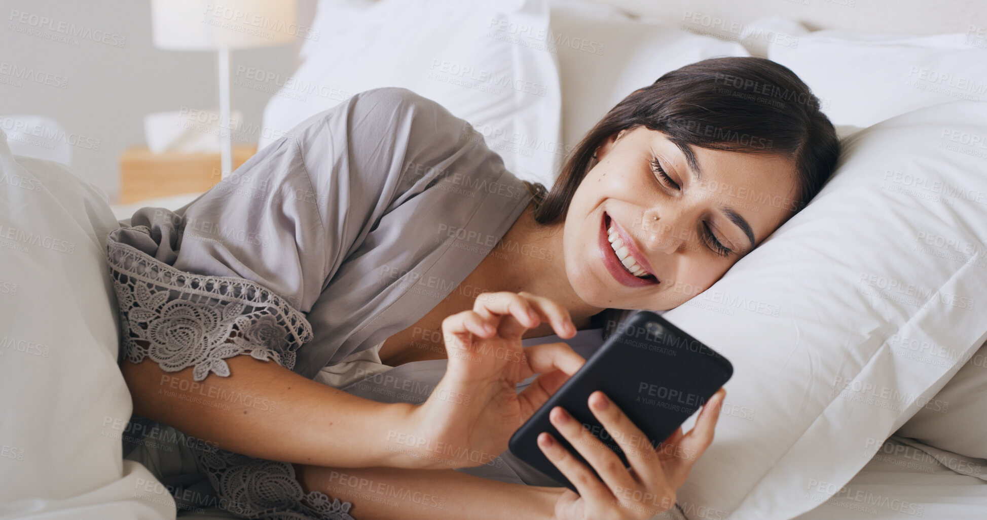 Buy stock photo Smile, mobile and woman relax in bedroom for text, message or reading post on social media. Morning, bed and girl in home with phone for communication, scroll and online chat with app notification