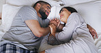 Smile, couple and relax on bed at house with love, wake up and calm morning on honeymoon. Above, people and rest with holding hands for romance, affection and bonding together for marriage commitment
